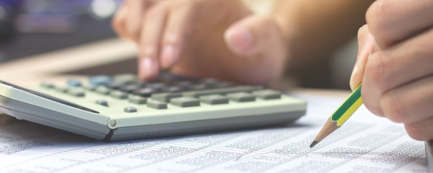 Close-up Businessman accountant hand holding pencil working on c Close-up Businessman accountant hand holding pencil working on calculator to calculate financial data report. business financial concept.